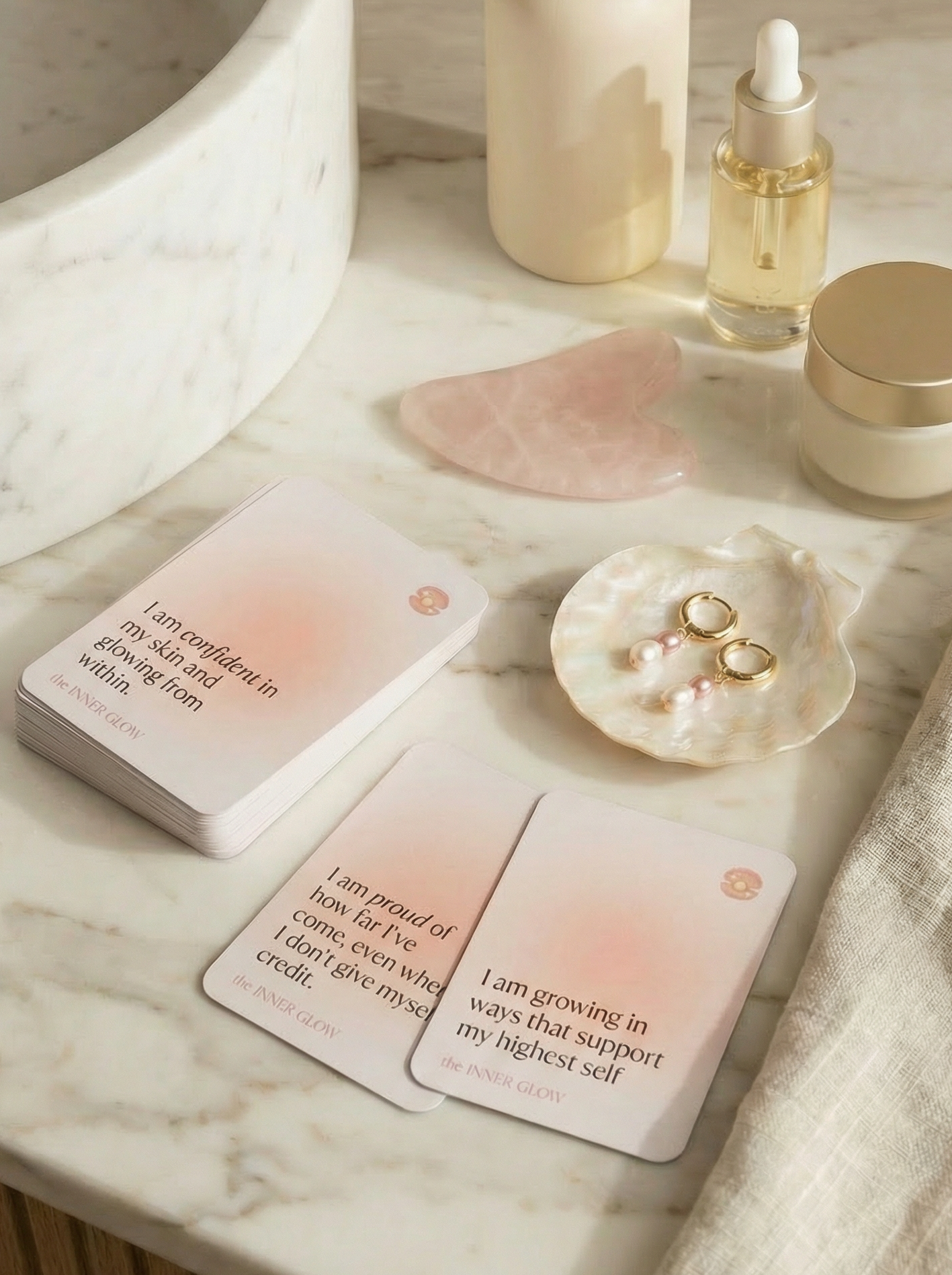 Skincare products and affirmation cards on a marble surface